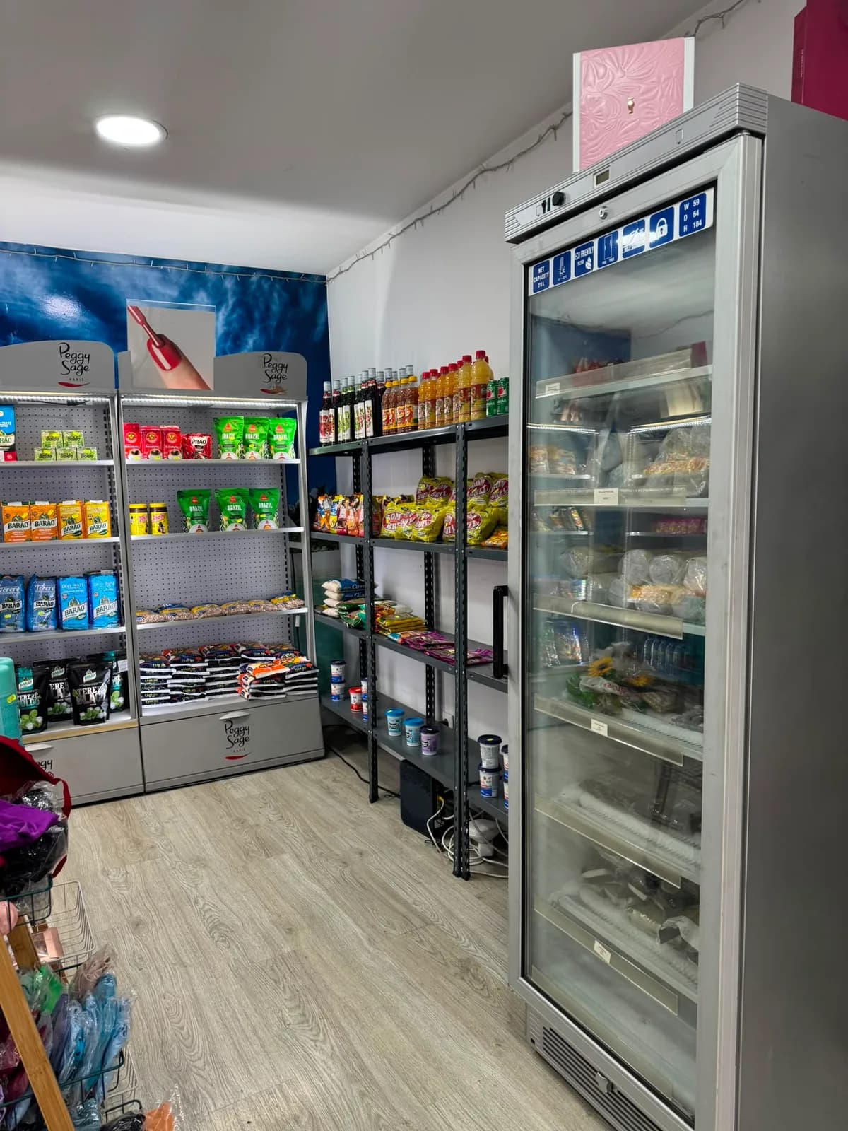 Arca frigorífica com congelados, ao lado das prateleiras de mercearia