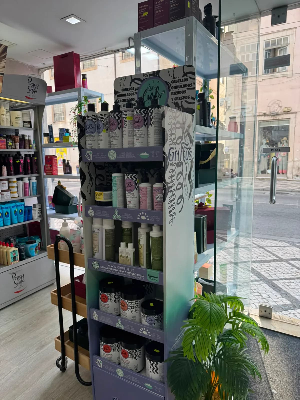Expositor de perfumaria ao lado da montra, com vista para a Rua da Sofia
