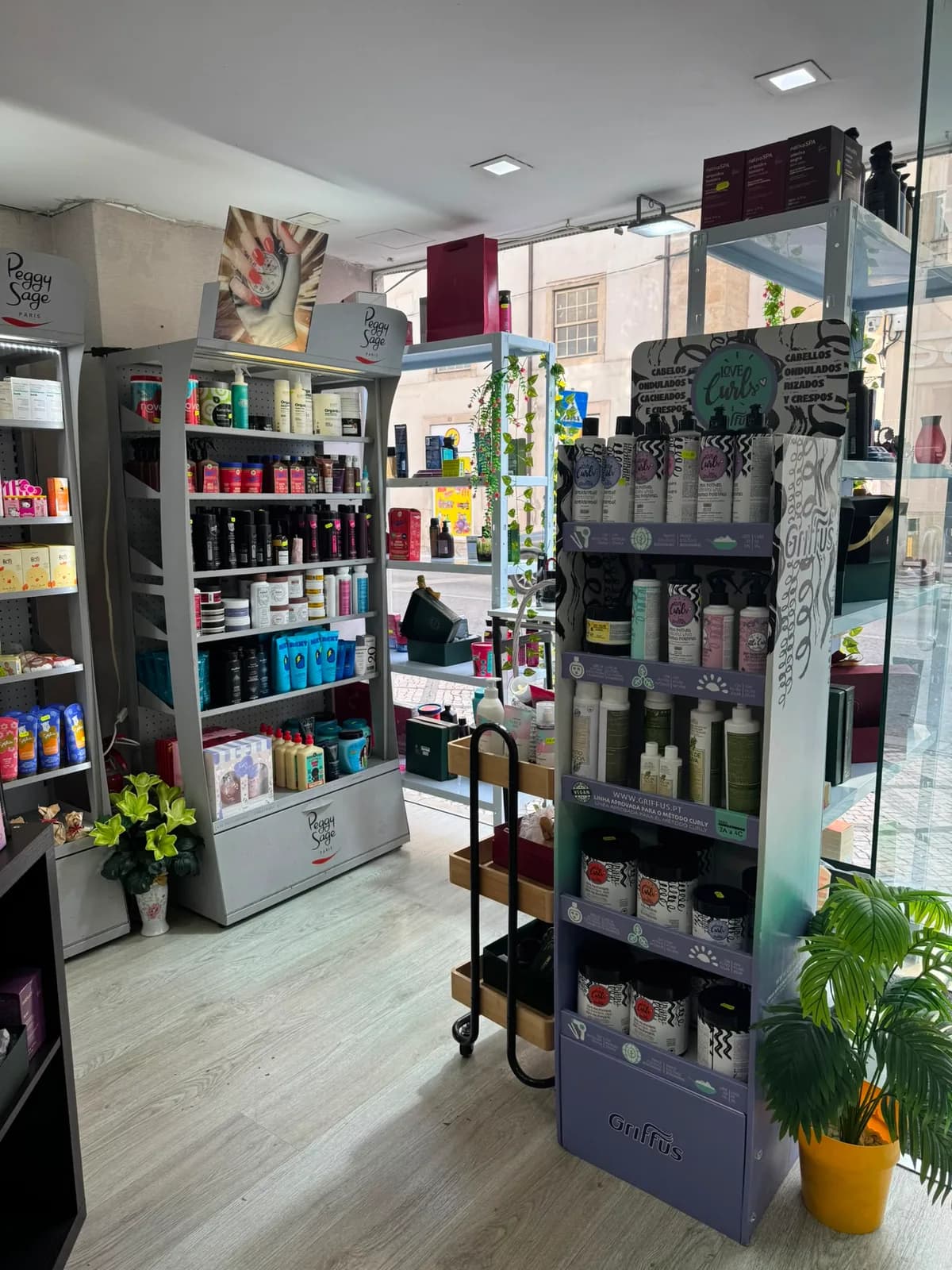Zona de perfumaria e cuidado pessoal do Zuca Mercado, junto à montra, com prateleiras de cremes e produtos de banho
